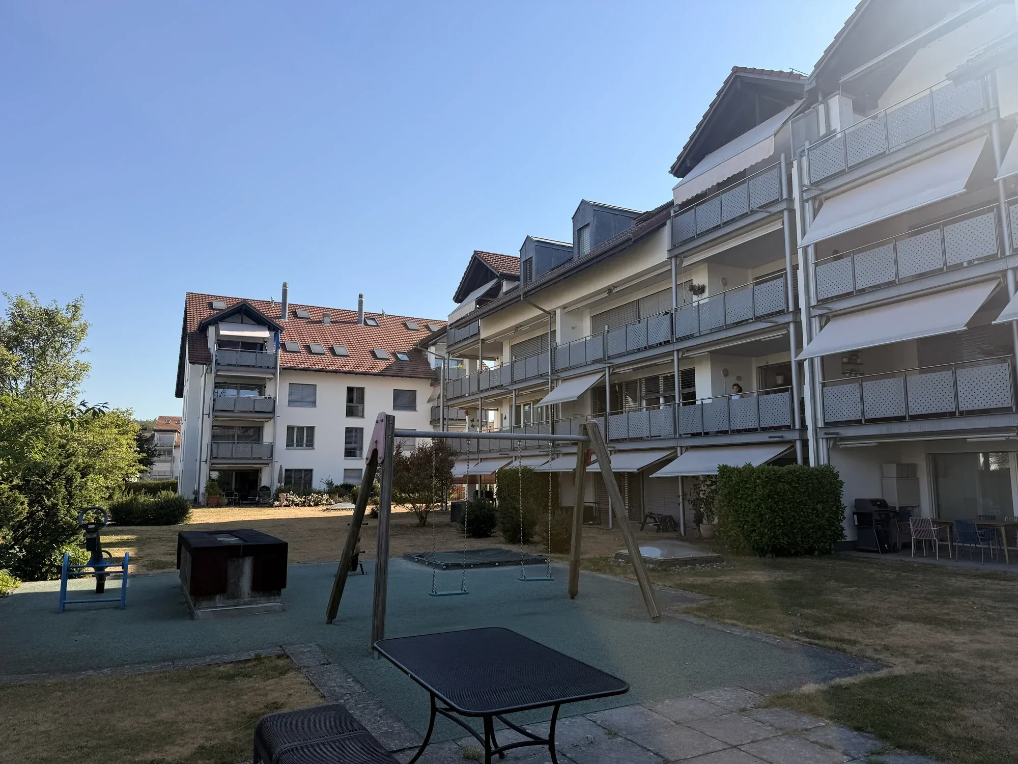 Innenhof mit Spielplatz und Sitzplatz – betreut von PHH Hofer Hauswartungen, Zürich & Aargau